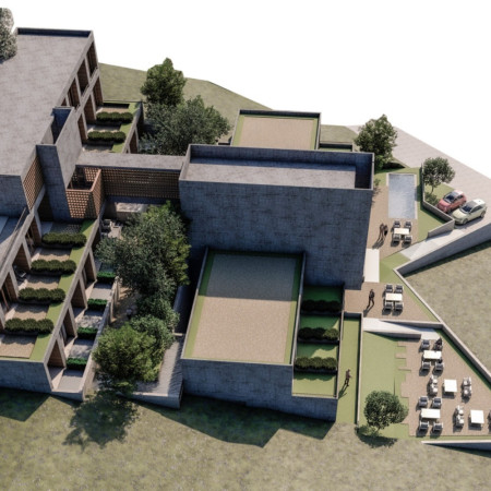 Charred Wooden Shingles and Natural Stone Harmonize Accessibility in a Community-Focused Space