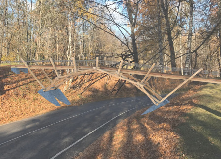 Arched Span of Oak and Steel Enhancing Pedestrian Access in Natural Landscapes  