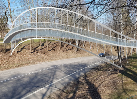 Curvilinear Footbridge Crafted From Stainless Steel and Natural Timber Integrating Accessibility in a Scenic Landscape