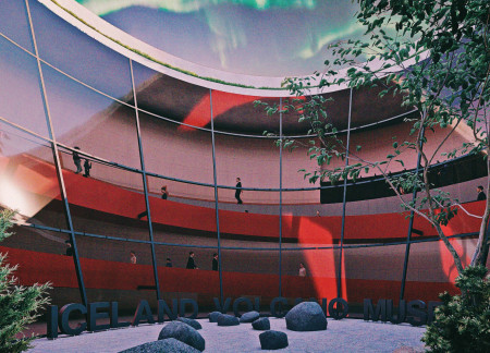 Curved Massing of Volcanic Rock and Tinted Glass in a Geological Education Center