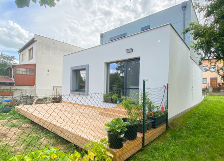 Metal Siding and Vertical Lines Define a Sustainable Family Residence in a Suburban Landscape